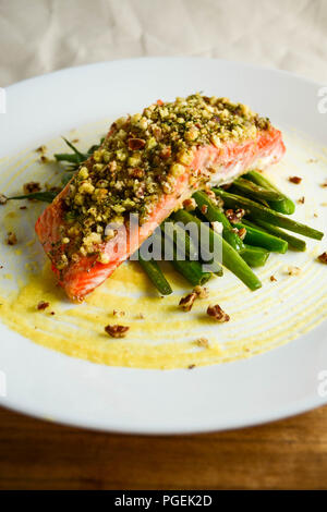 Honig und Dijon Senf gebackenen Lachs mit Pekannüssen und Dill, serviert mit grünen Bohnen auf einem weißen Teller Stockfoto