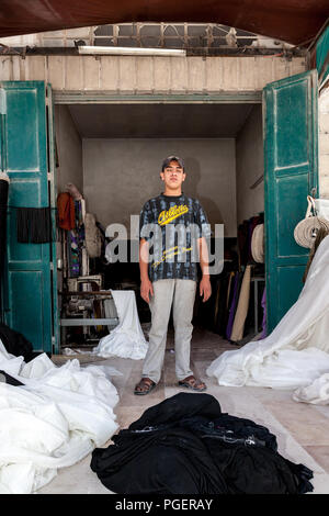 Hebron, Palästina, 3. August 2014: Palästinensischen jungen Erwachsenen stehen in einer Tür eines Sägen Werkstatt. Stockfoto