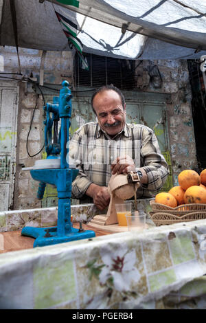 Hebron, Palästina, 21. Juni 2014: Palästinensische Männer verkauft gedrückt frischen Orangensaft auf den Straßen der Altstadt von Hebron. Stockfoto