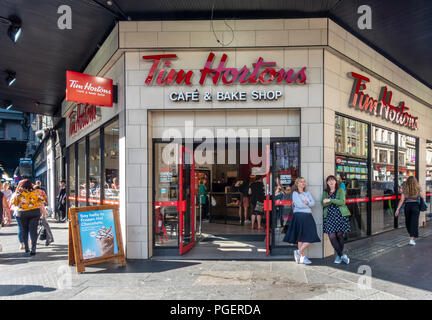 Tim Hortons Cafe und Bäckerei im Zentrum von Glasgow mit Kunden im Shop und Fußgänger/Käufer auf dem Bürgersteig vor der Tür. Schottland, Großbritannien. Stockfoto