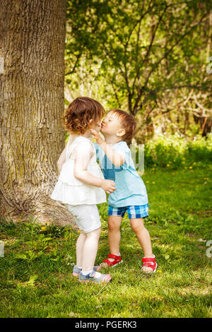 Porträt von zwei cute adorable Baby Kinder Kleinkinder umarmen und küssen einander, Liebe Freundschaft in der Kindheit Konzept, beste Freunde für immer Stockfoto