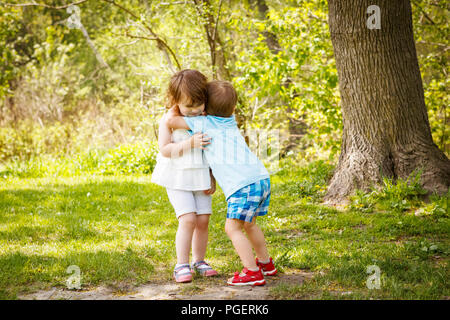 Porträt von zwei cute adorable Baby Kinder Kleinkinder umarmen und küssen einander, Liebe Freundschaft in der Kindheit Konzept, beste Freunde für immer Stockfoto