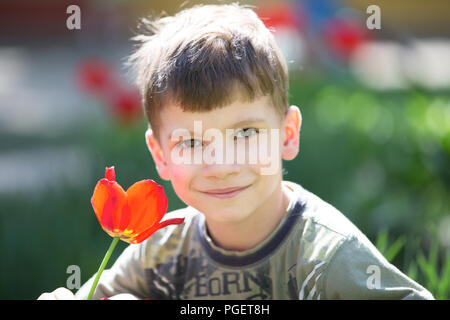 Belarus, die Stadt Gomel, April 04, 2018. Die zentrale Kindergarten. Tag geöffnet. Portrait von sechs, sieben Jahre alten Jungen auf der Straße mit Tulpen Stockfoto