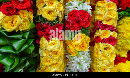 Girlande mit Blumen in verschiedenen Farben sind für den Kauf in einem indischen Markt verfügbar Stockfoto