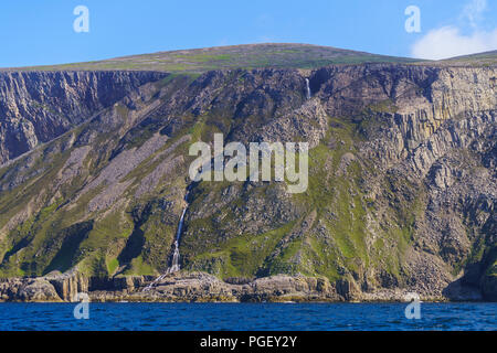 Ein Wasserfall Kaskaden hinunter das Gesicht eines Sea Cliff auf der Insel Rum. Rum ist eine der kleinen Inseln der Inneren Hebriden in Schottland. Stockfoto