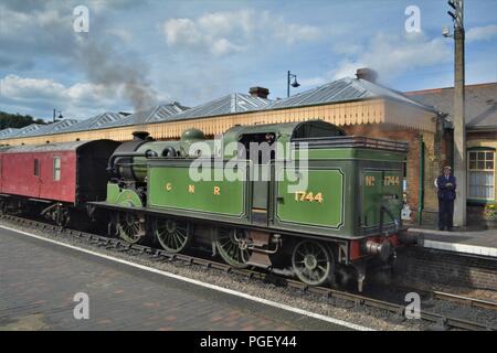 1744 grüne Dampfeisenbahn am alten Sheringham Bahnhof, schiebt, Kutschen. Stockfoto