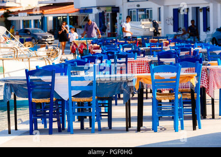 Tische und Stühle von Restaurants vor dem Meer mit unscharf Hintergrund Elafonisos Island, Lakonien, Griechenland Stockfoto