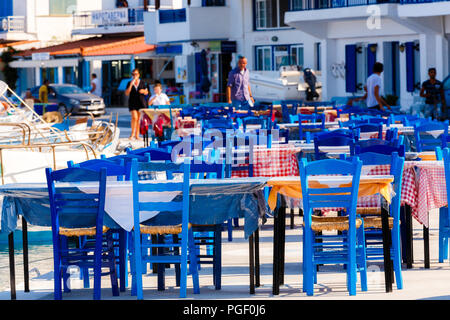 Tische und Stühle von Restaurants vor dem Meer mit unscharf Hintergrund Elafonisos Island, Lakonien, Griechenland Stockfoto
