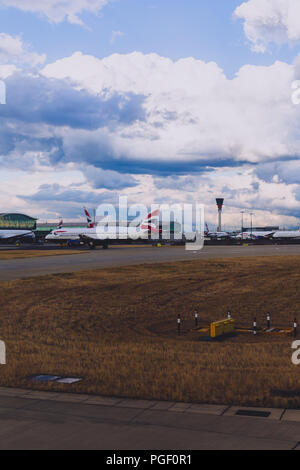 LONDON, Großbritannien - 10. August 2018: die Aussicht auf den Flughafen Heathrow mit stürmischen Himmel und British Airways Flugzeuge auf ihren Messeständen Stockfoto