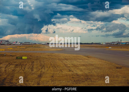 LONDON, Großbritannien - 10. August 2018: die Aussicht auf den Flughafen Heathrow mit stürmischen Himmel und Flugzeuge auf ihren Messeständen Stockfoto