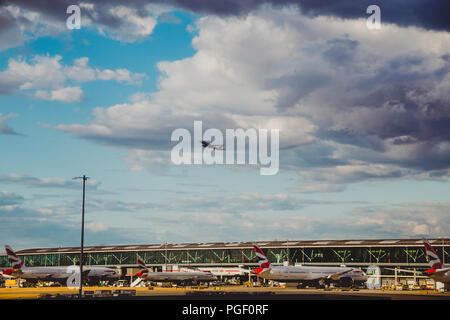 LONDON, Großbritannien - 10. August 2018: die Aussicht auf den Flughafen Heathrow mit stürmischen Himmel und British Airways Flugzeuge auf ihren Messeständen Stockfoto