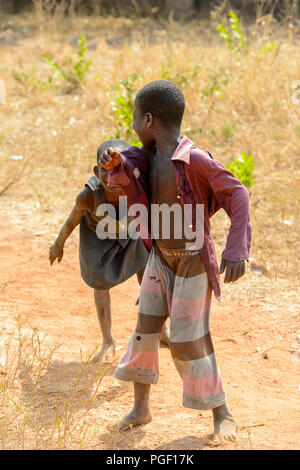 GHANI, GHANA - Jan 14, 2017: Unbekannter Ghanaischen kleines Mädchen versteckt sich hinter den Jungen in einem lokalen Dorf. Ghana Menschen leiden unter der Armut aufgrund der schlechten Stockfoto