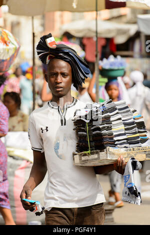 LOME, TOGO - Jan 9, 2017: Unbekannter Togoischen junge Mann trägt einen Satz Socken an der Lome zentralen Markt. Togo Menschen leiden unter der Armut aufgrund der Stockfoto