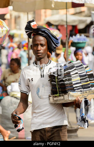 LOME, TOGO - Jan 9, 2017: Unbekannter Togoischen junge Mann trägt einen Satz Socken an der Lome zentralen Markt. Togo Menschen leiden unter der Armut aufgrund der Stockfoto