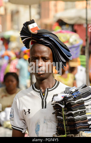 LOME, TOGO - Jan 9, 2017: Unbekannter Togoischen junge Mann trägt einen Satz Socken an der Lome zentralen Markt. Togo Menschen leiden unter der Armut aufgrund der Stockfoto