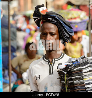 LOME, TOGO - Jan 9, 2017: Unbekannter Togoischen junge Mann trägt einen Satz Socken an der Lome zentralen Markt. Togo Menschen leiden unter der Armut aufgrund der Stockfoto