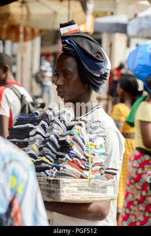 LOME, TOGO - Jan 9, 2017: Unbekannter Togoischen junge Mann trägt einen Satz Socken an der Lome zentralen Markt. Togo Menschen leiden unter der Armut aufgrund der Stockfoto