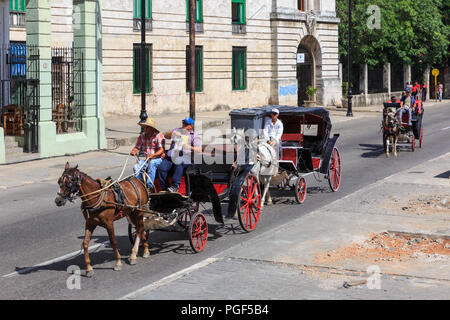 Von Pferden gezogene Kutschen und Karren als Touristische Taxis auf der Straße, Straße in der Altstadt von Havanna, Kuba Stockfoto
