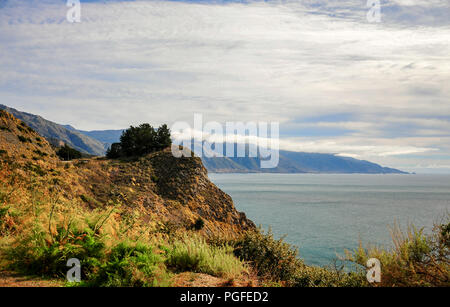 Schöne Szene entlang Big Sur Autobahn, Pfeiffer Big Sur State Park, Kalifornien. Felsigen Landzunge mit farbenfrohen Vegetation gegen dunstigen Hintergrund Stockfoto