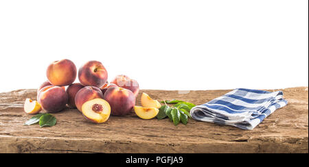 Frisch reife Pfirsiche auf dem alten Holztisch mit einem isolierten weißen Hintergrund geeignet für eine Fotomontage. Stockfoto