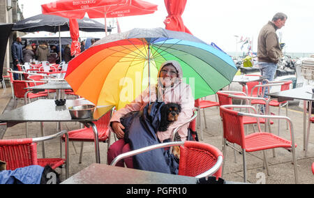 Brighton UK 26. August 2018 - Dieser Hund und Besitzer bleiben trocken auf Brighton Seafront in der Wind und der Regen da schlechtes Wetter fegt über der Südküste heute, aber die Prognose ist für es für August Bank Holiday Montag: Simon Dack/Alamy Leben Nachrichten verbessern Stockfoto