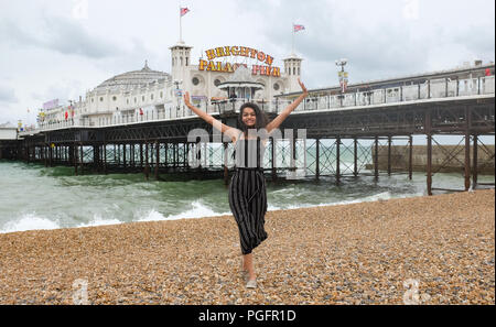 Brighton UK 26. August 2018 - eine junge Frau genießt selbst noch auf Brighton Beach trotz Wind und Regen da schlechtes Wetter fegt über der Südküste heute, aber die Prognose ist für es für August Bank Holiday Montag Foto von Simon Dack Credit: Simon Dack/Alamy Leben Nachrichten: Simon Dack/Alamy Leben Nachrichten zu verbessern. Stockfoto