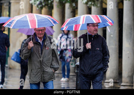 Badewanne, UK, 26 August, 2018. Zwei Männer mit Union Jack Schirme trocken zu halten sind trotzen Regen in der Badewanne als heftiger Regenschauer ihren Weg über Südengland. Credit: Lynchpics/Alamy leben Nachrichten Stockfoto