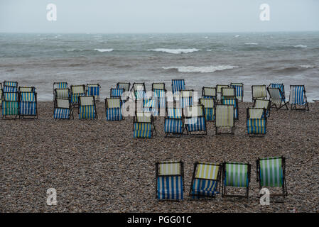 Bier, East Devon, Großbritannien. 26. August 2018. UK Wetter: Der schöne Strand im Fischerdorf Bier war leer von Urlaubern als sintflutartigen Regenfällen der Südküste Urlaub Wochenende getroffen. Reihen von Liegestühlen lagen leere auf, was normalerweise einer der verkehrsreichsten Wochenenden des Jahres für das Dorf. Credit: Celia McMahon/Alamy leben Nachrichten Stockfoto