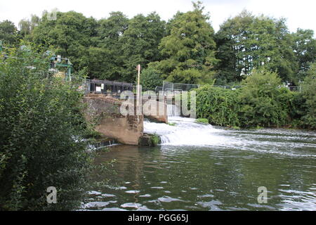 Wasser wird über ein Wehr auf der Wey bei Walsham Sperren Stockfoto