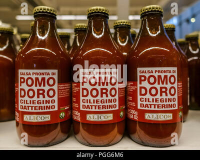 Tomatenpüree Tomaten pürieren, Sauce für Pasta für den Verkauf angezeigt. Geschälte Tomaten Sauce Flaschen auf einem Regal ausgerichtet. Mediterrane Ernährung. Close Up. Stockfoto