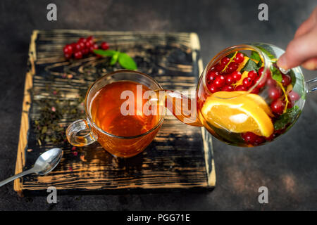 Gießen Kräuter Tee im Glas Schale Stockfoto