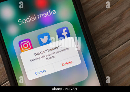 OXFORD, UK - 22. AUGUST 2018: ein Twitter Benutzer löscht den Social Media App aus einem Smartphone. Stockfoto