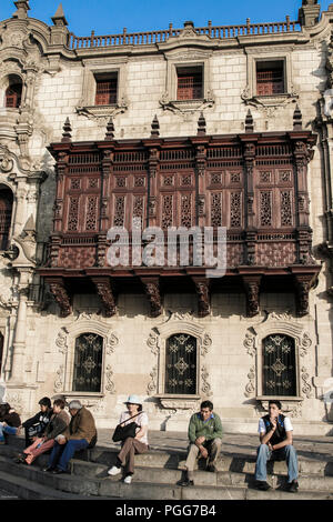 Menschen sitzen auf den Stufen des Palacio Arzobispal auf der Plaza de Armas, Lima, Peru Stockfoto