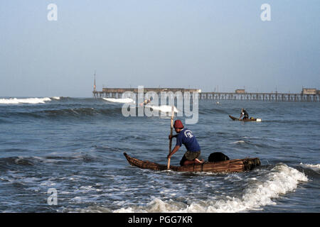 Caballitos de totora Reed boot Fischer paddeln durch Wellen zu Fischbeständen in Pimentel, Peru Stockfoto