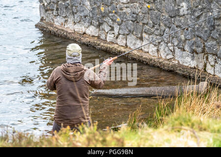 Mann angeln am Strand von Llyn Ogwen, Wales - UK. Stockfoto