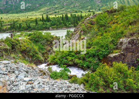 Mountain Creek unter Klippen unter Felsbrocken in die Katun Flusses in Altai Gebirge fließt, Russland - schöne Sommer Landschaft. Die Schönheit der wilden Natur Stockfoto