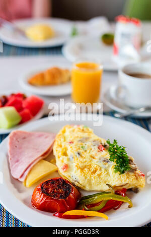 Köstliches Frühstück mit Omelette, Schinken und Gemüse Stockfoto