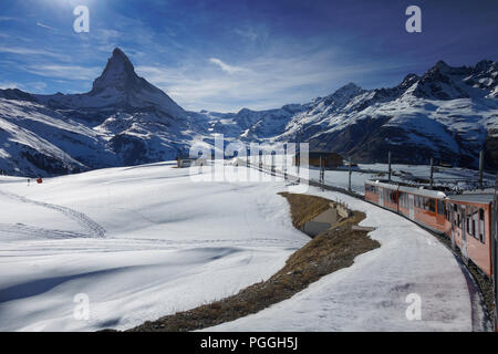 Zug der Gornergrat Bahn durch den Schnee mit Blick auf das Matterhorn im Winter hoch über Skigebiet Zermatt, Wallis, Schweiz. Stockfoto