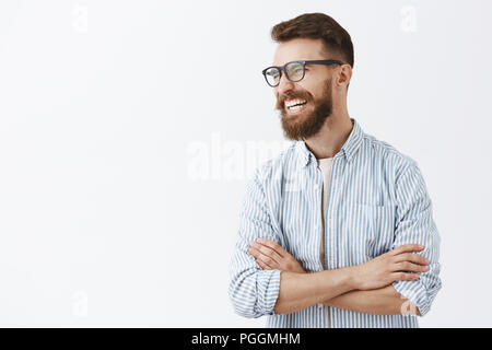 Kreative fröhlich und lustig bärtiger Mann mit Schnurrbart in Brille mit schwarzem Rand links vor Lachen, laut genießen, interessante und witzige Unterhaltung, Hände auf der Brust gekreuzt entspannt Stockfoto