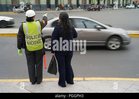 LIMA, PERU - 16. JULI 2010: Polizistin etwas betont, zu einer Dame. Stockfoto