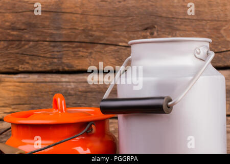 Emaillierte Milch Dosen mit Deckel. Weiß und Orange Milch Dosen mit Deckel. Stockfoto