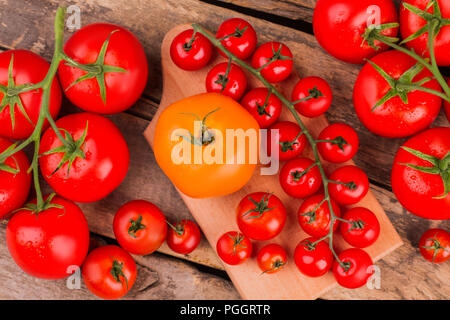 Ernte der Tomaten auf hölzernen Schreibtisch für das Kochen. Ansicht von oben. Rote und gelbe frische reife Tomaten gewaschen. Stockfoto