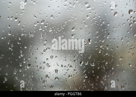 Regentropfen auf Fenster, regnerischen Wetter. Abstrakte grauer Hintergrund, Textur der Regen fällt auf Glas Stockfoto