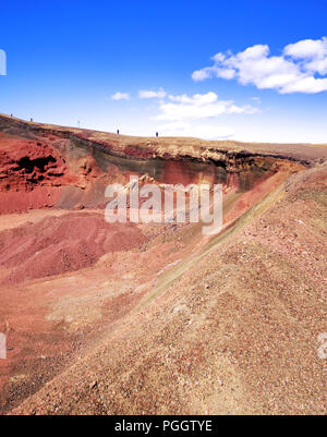 Blick in einen roten vulkanischen Krater mit Besuchern, die am Rand Islands entlang laufen Stockfoto