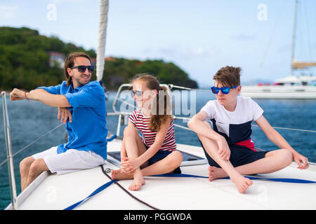 Vater und Kinder an Bord der Segelyacht in Sommer reisen Abenteuer Stockfoto