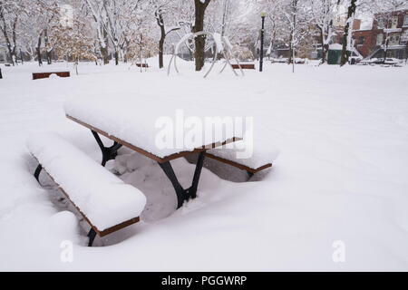 Der erste Schnee hat sich auf alles, was während der Nacht gefallen. Ein Picknick Tisch ist der Schnee in einem öffentlichen Park. Stockfoto