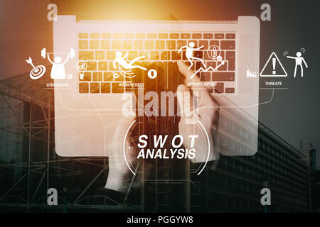 SWOT-Analyse virtuelle Diagramm mit Stärken, Schwächen, Möglichkeiten und Risiken des Unternehmens. Business hand Smartphone mit Laptop. Stockfoto