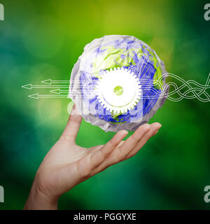 Gedanken über die Strukturierung der virtuellen Abbildung der Geschäftsprozesse mit Lösungen. Hand, zerknittertes Papier Welt Symbol als Konzept auf grünem Hintergrund Stockfoto