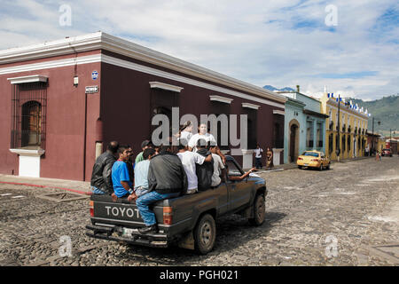 Männer sitzen in überlastetem Pickup-Truck in Antigua Guatemala, Guatemala Stockfoto