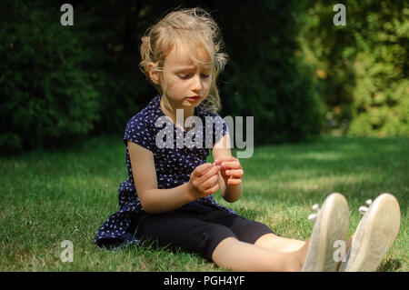 Lustige überrascht kleine blonde Mädchen, das schreiend in den Park. Im freien Portrait von Happy Interaktive weiblichen Kind. Stockfoto